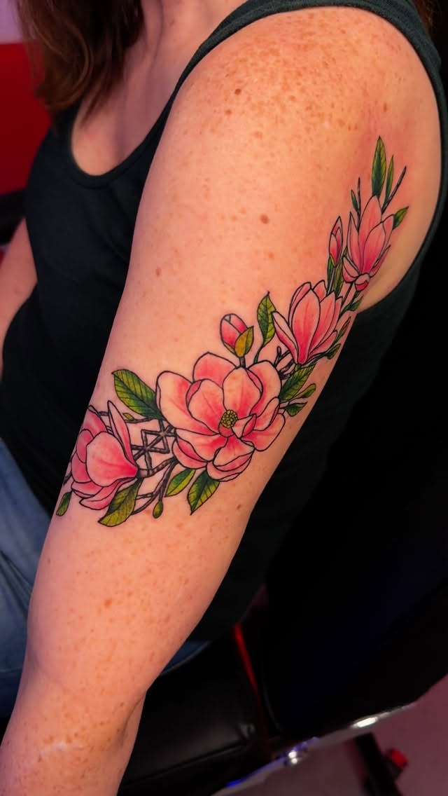 Color floral blossom upper arm tattoo